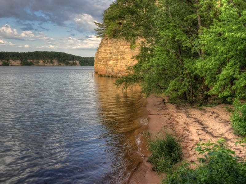 where to go in Wisconsin in April, cliffs and trees along shoreline on a grey day