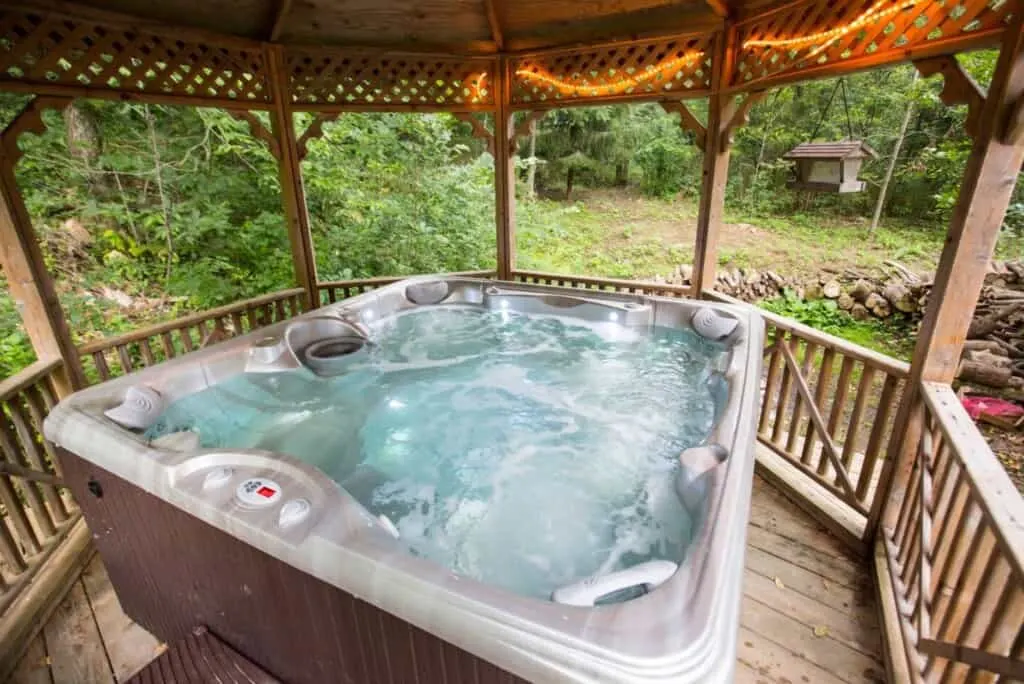 hot tub on a porch at one of the best one of the best Romantic Secluded Cabins In Wisconsin