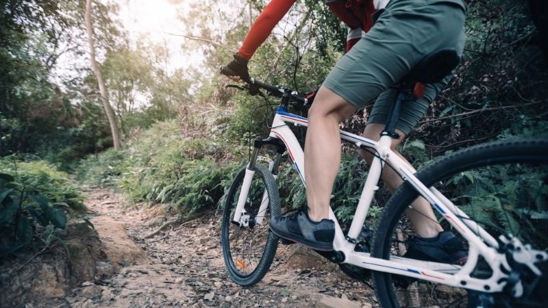 Best Mountain Bike Trails in Lake Geneva, cyclist riding mountain bike on rocky trail at sunny day