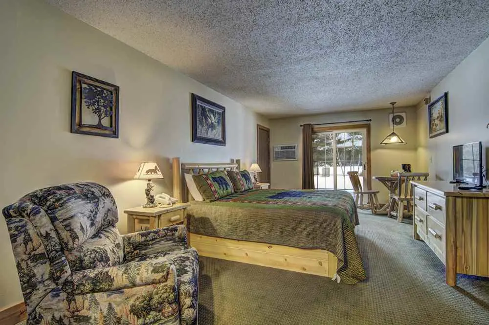 Northern Wisconsin winter resorts, cozy room with a bed, table, chair and view of snow outside