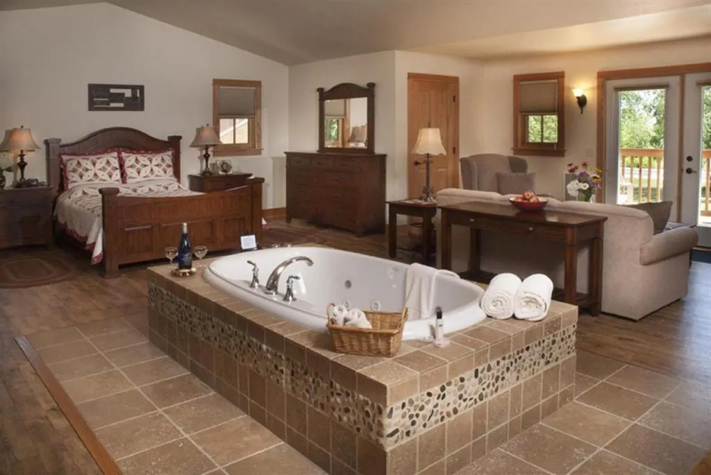 Wisconsin winter resorts for families, room with large bathtub, bed and sofa at Lake Orchard Farm Retreat