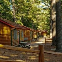 Best Family Resorts in Wisconsin, row of log cabins with outside seating area