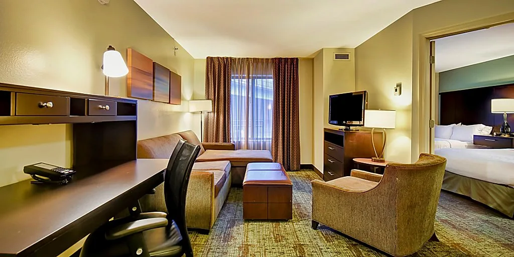 best resorts in wisconsin for families, suite with two beds,d esk and lounge area at staybridge suites