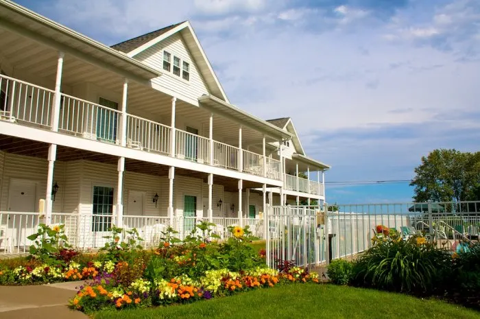 best places to stay in Door County on the water, outside of hotel with lots of flowers, pool area and lake just behind