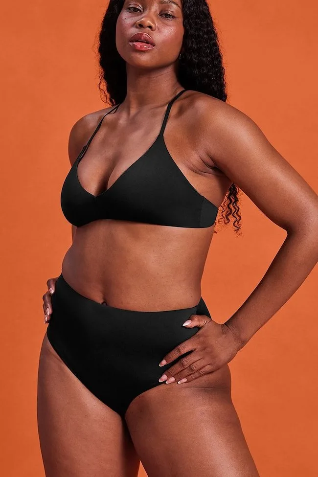 woman in black bikini from girlfriend collective; ethical swimwear brands for all sizes