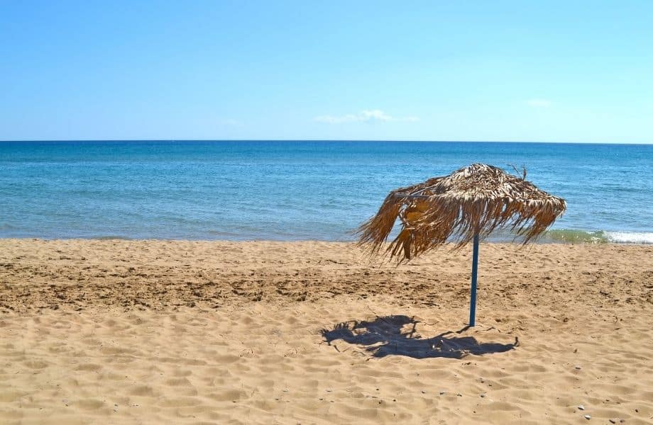 best Paros beaches, straw umbrella blowing in the wind on Glyfa Beach