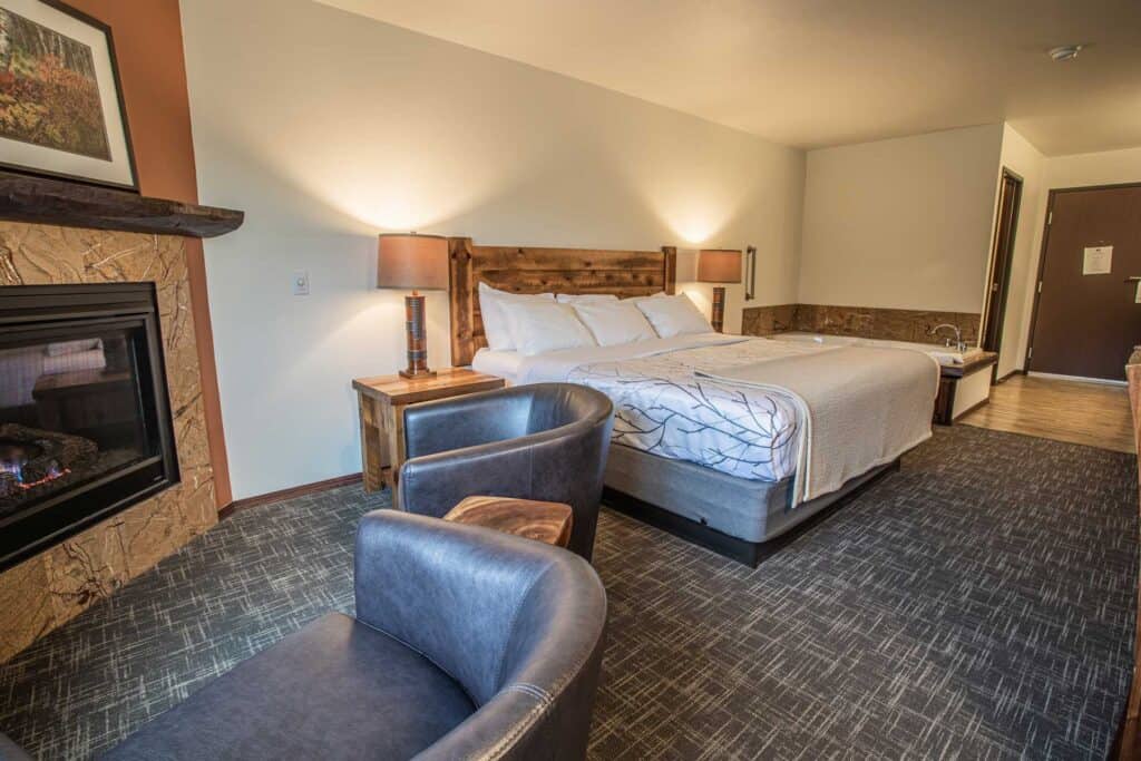 Top Door County places to stay, room with two chairs facing a fireplace next to a bed and whirlpool bathtub