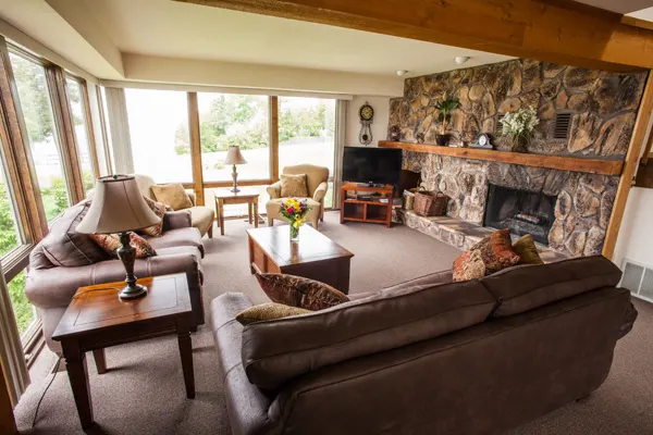 Best lakeside resorts in Door County Wisconsin, large living room area with two sofas, two chairs, coffee table, tv, fireplace and bay windows