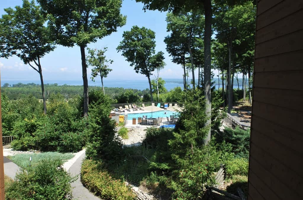 best places to stay in Egg Harbor, view from hotel room of the pool surrounded by trees and lake in distance