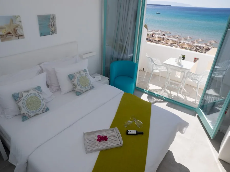 best resorts in paros greece, room with balcony overlooking beach and beach umbrellas at Amaryllis Beach Hotel
