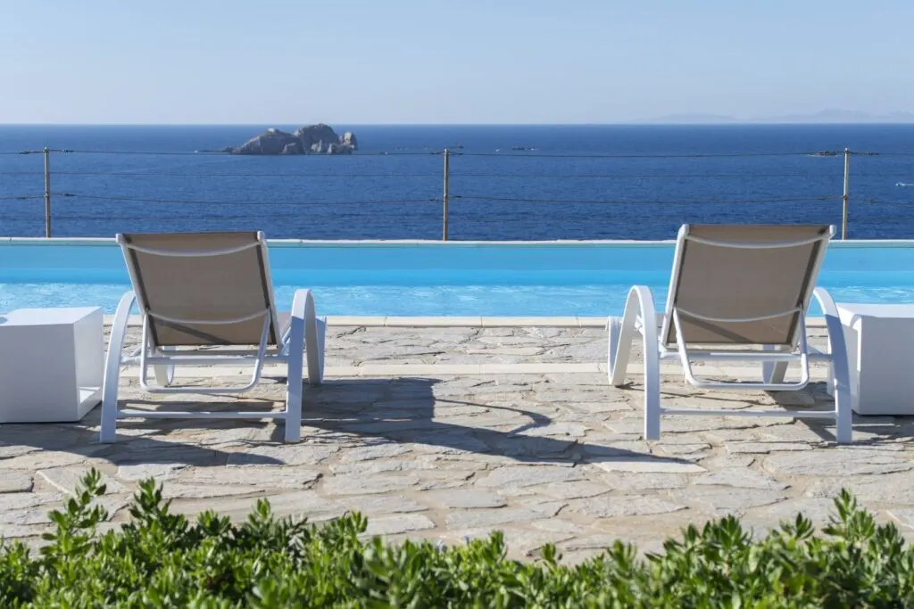 resorts in Paros amazing accomodation in Paros, Greece, two beach chairs overlooking pool and ocean at Archipelagos Resort & Villas