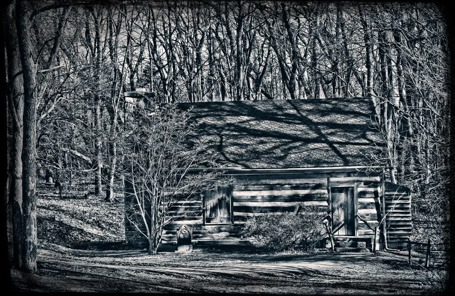 black and white photo of a cabin in the woods; get locked in a creepy cabin at one of the best escape rooms in Wisconsin Dells