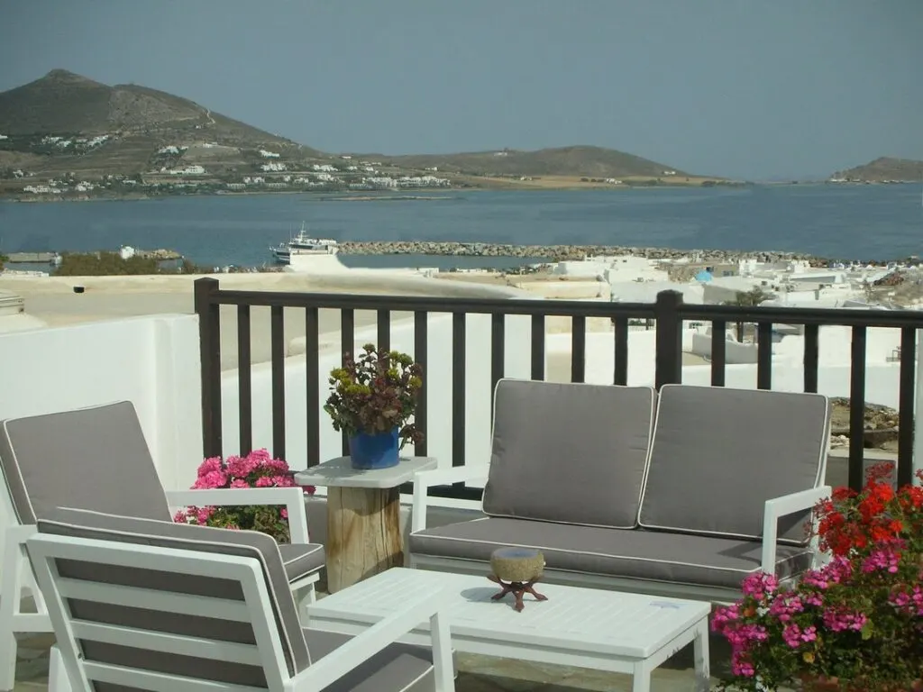 Paros beach resorts, deck withchairs, sofa and table overlooking the water at Christina Hotel Paros