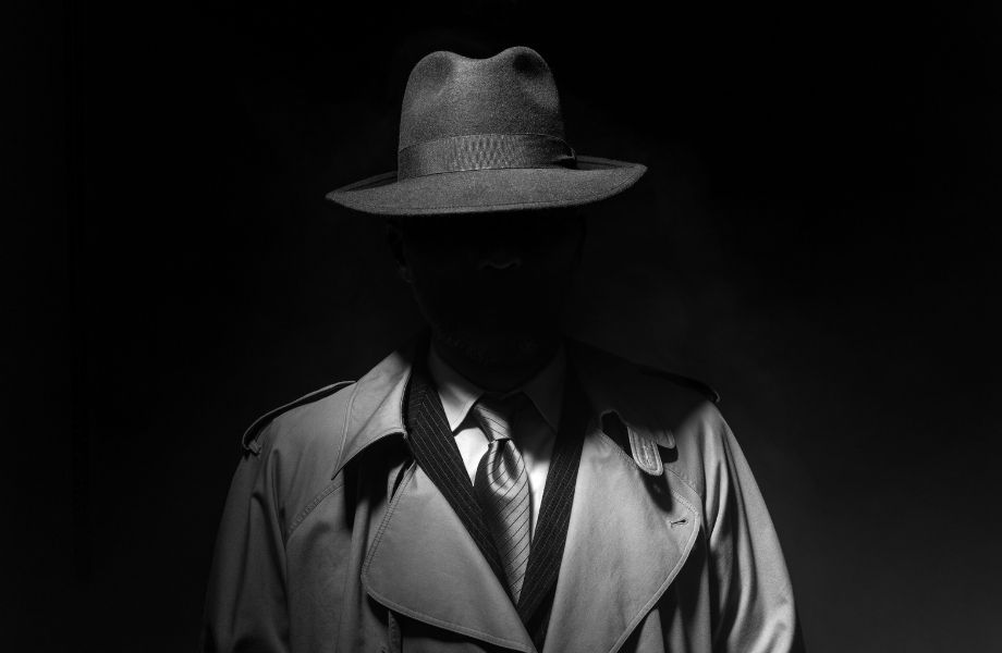man in jacket with hat hiding his face in shadow; enjoy a film noir puzzle at the Appleton escape room