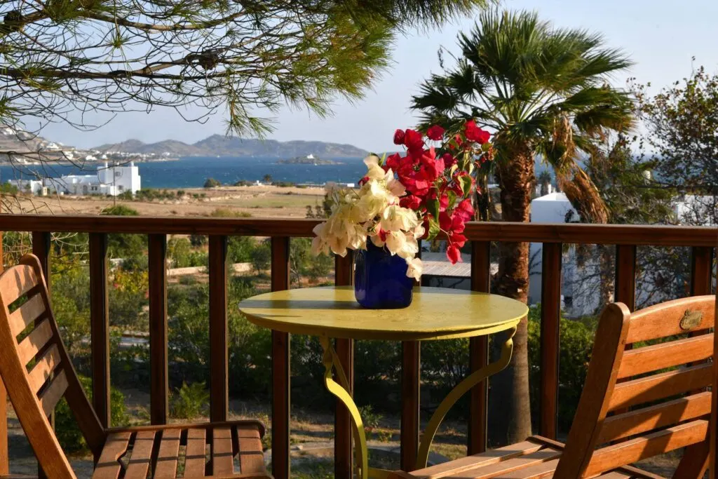 amazing accommodation in Paros Greece, table and chairs on balcony overlooking town and beach