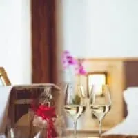 Most Romantic Hotels in Wisconsin, table with wine in ice bucket, chocolates and two wine glasses with bed in background