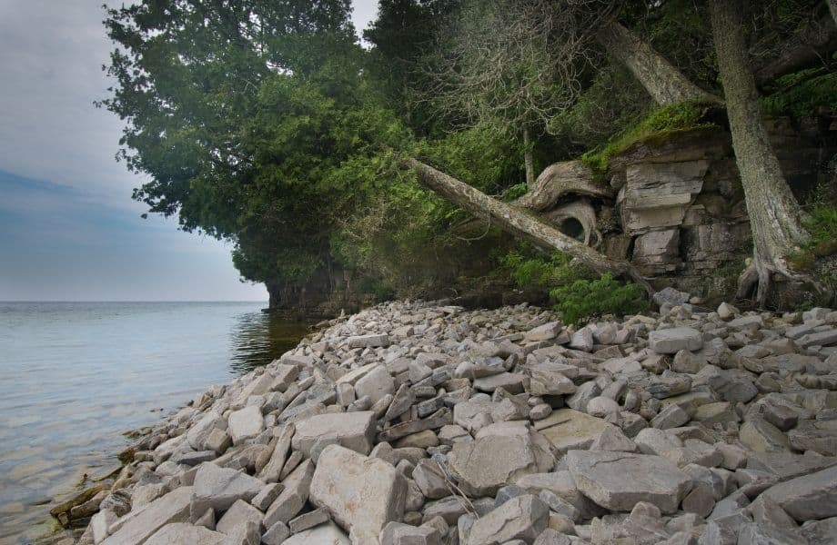 rocky coastline of Rock Island Wisconsin with trees at the back