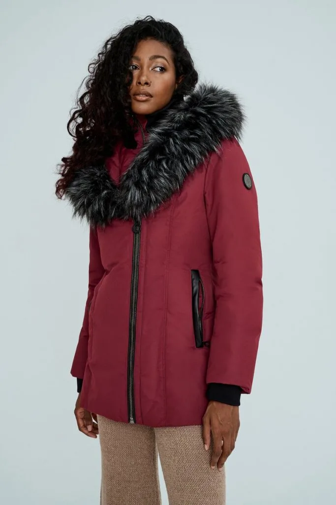 sustainable women's winter coats, woman in red parka with faux fur