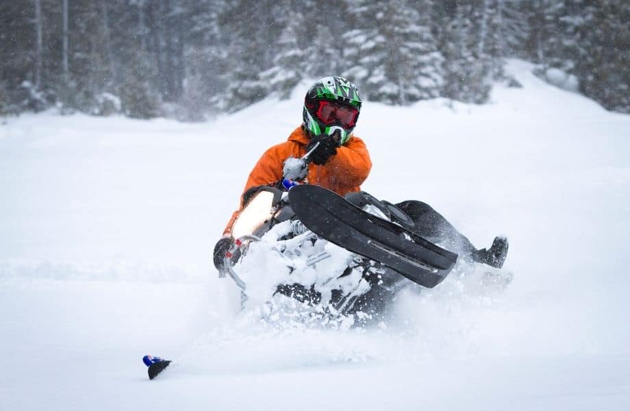 places to visit in Wisconsin during winter, person riding snowmobile around some of the best winter cabin rentals in Wisconsin