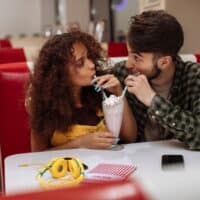 best date ideas in Milwaukee, couple sharing a milkshake at a diner