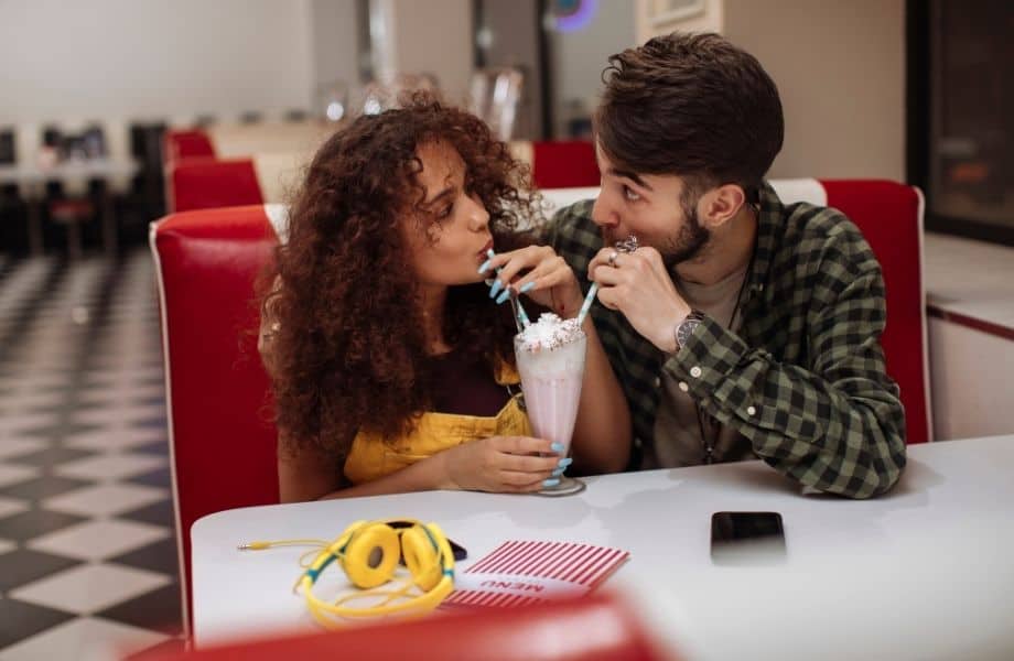 best date ideas in Milwaukee, couple sharing a milkshake at a diner