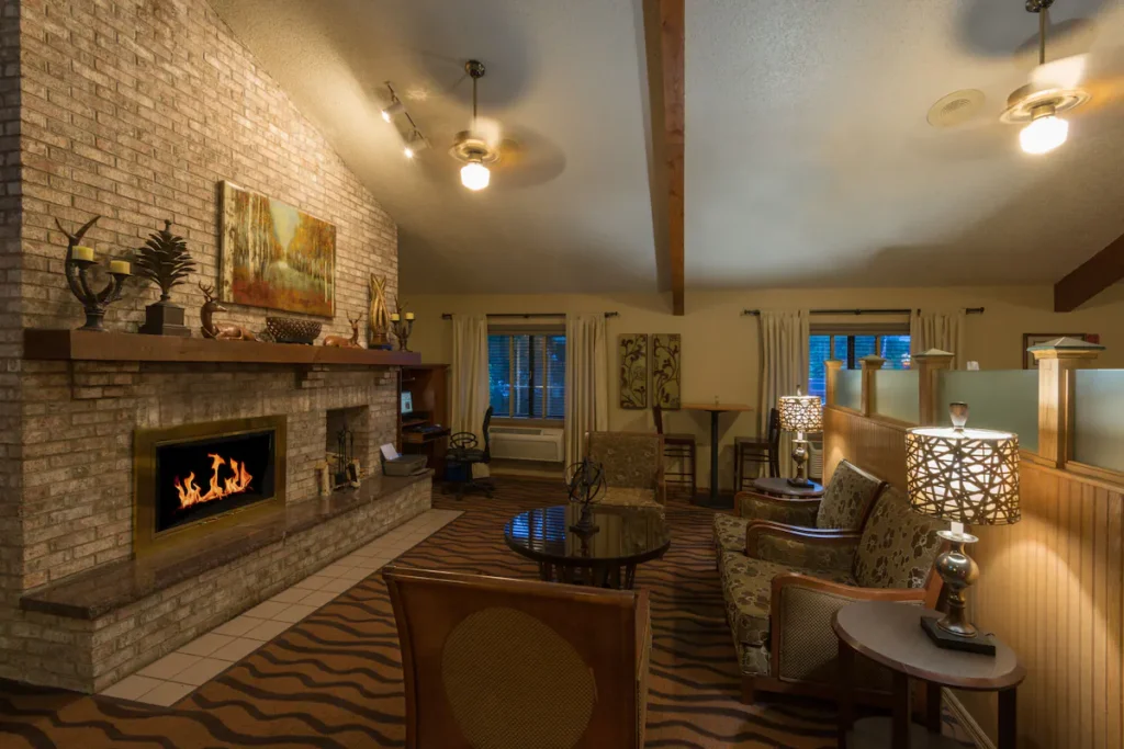 best hotels in Minocqua, WI, welcome area of hotel with chairs around an electric fireplace