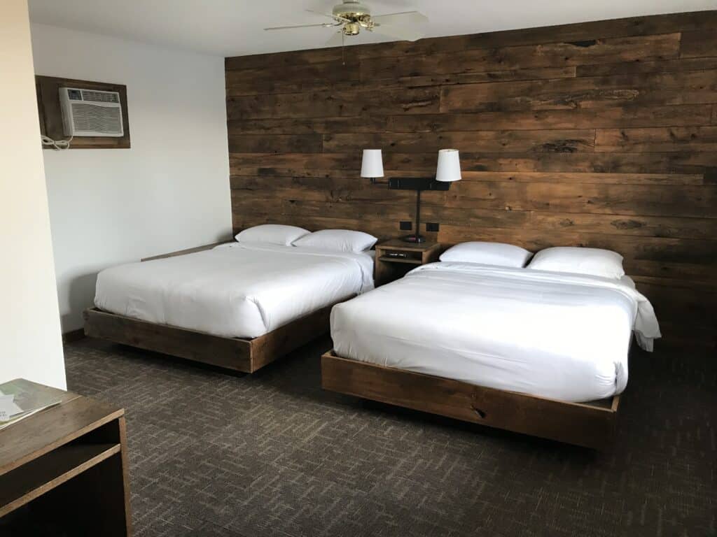 best motels in Minocqua, WI, simple room with wooden wall and two queen beds