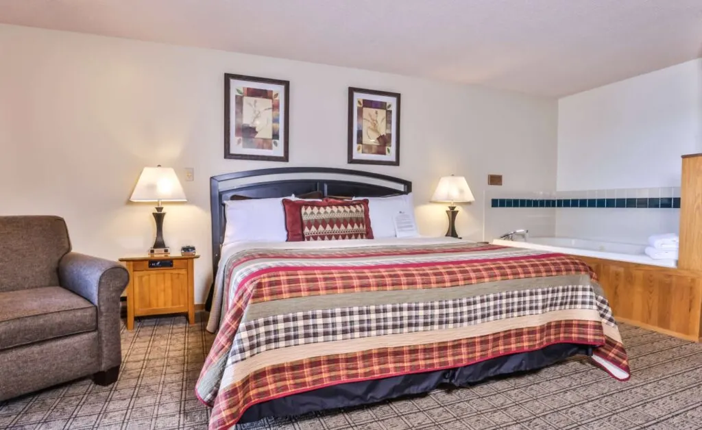 Minocqua area resorts, hotel room with bed, armchair and hot tub