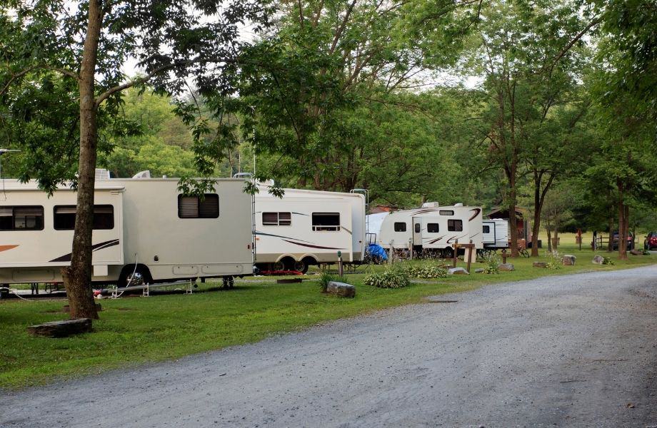 best wisconsin dells campgrounds for rvs, row of rvs along a road lined with trees