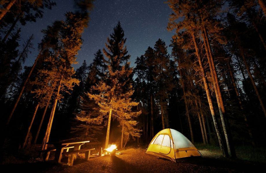 campground near wisconsin dells, lone tent out in the wilderness with fire at night under the stars