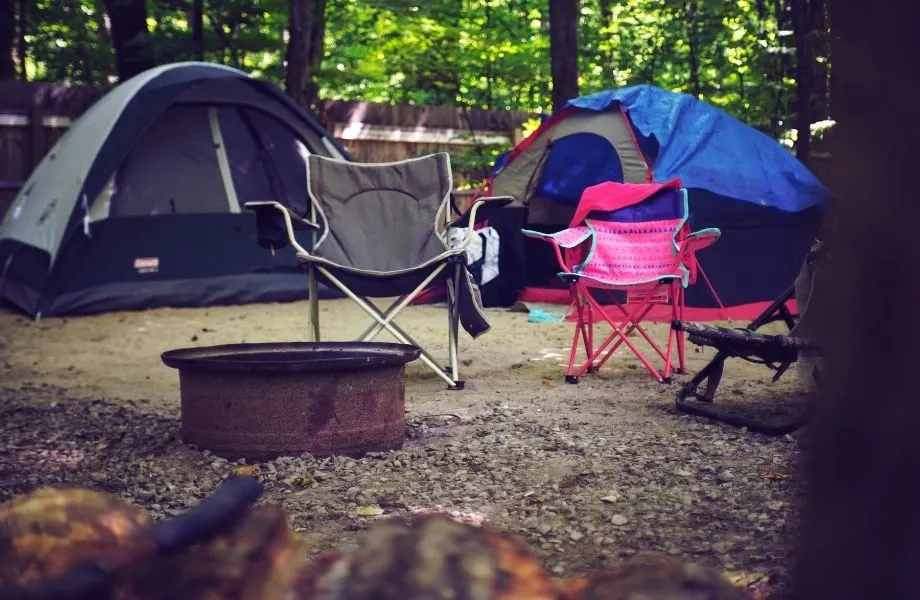 where to go for wisconsin dells camping, tents next to a metal fire bin and fold up camping chairs
