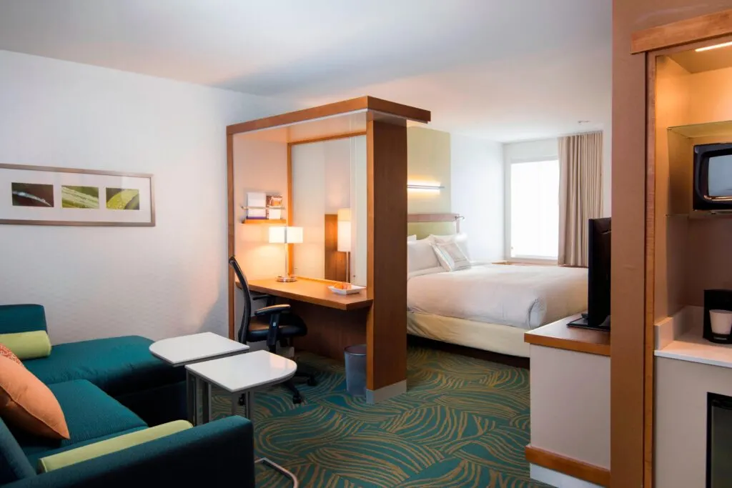 best hotels in Wisconsin Dells, hotel room with bed and sofa and a tall desk that divides the room