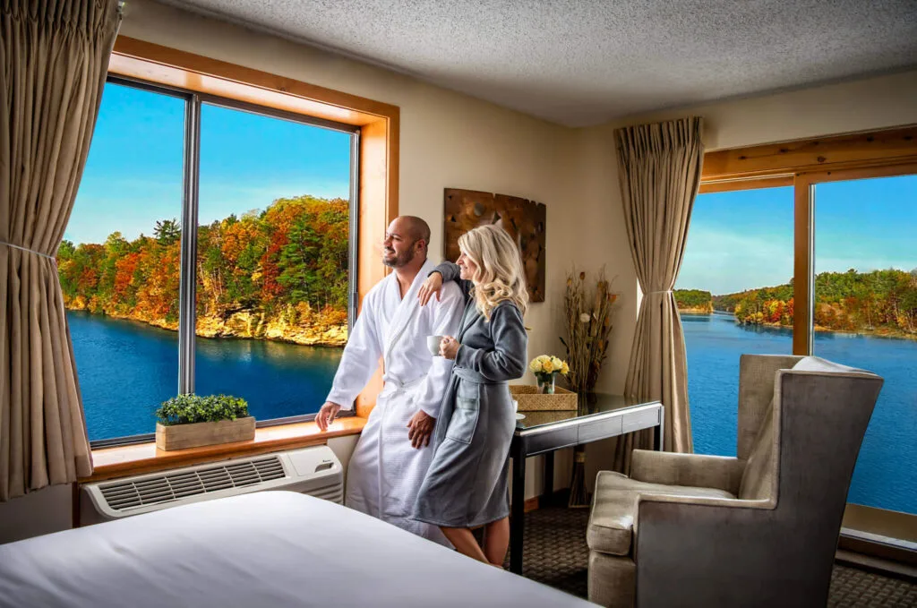 romantic places to sta in wisconsin dells, couple in bathrobes looking out of windows at the lake