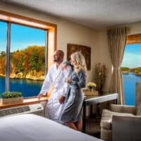 romantic resorts in wisconsin, couple in bathrobes looking out of windows at the lake