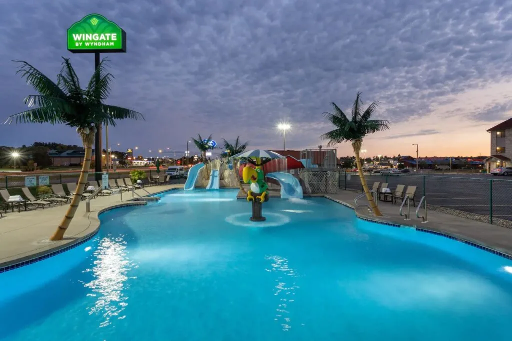 Wisconsin Dells waterpark hotels, hotel sign next to small outside waterpark with slides and palm trees