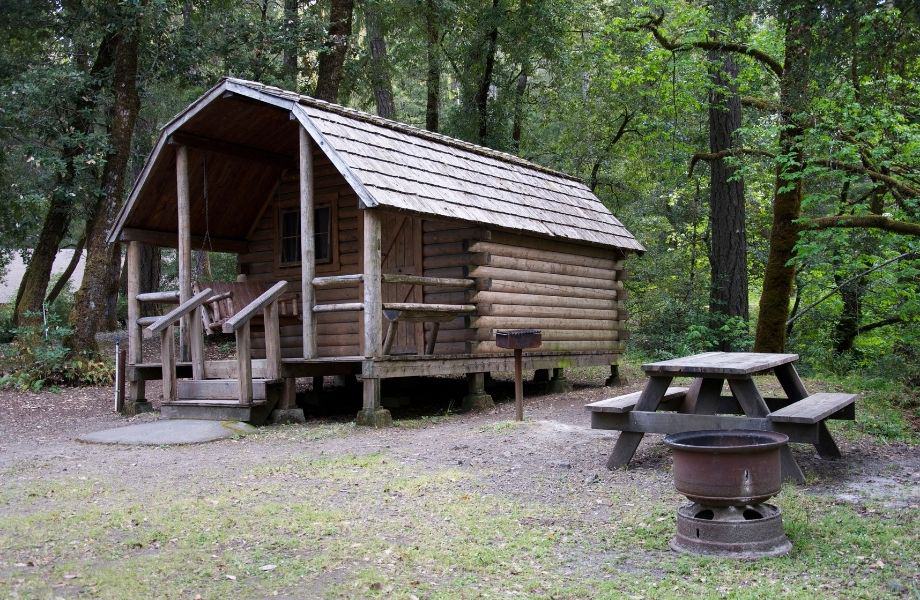 camping cabin rentals in wisconsin dells, cabin with table and fire area surrounded by trees