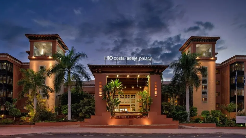 Luxury family hotels in Costa Adeje, exterior view of H10 Costa Adeje Palace at night with hotel sign lit up