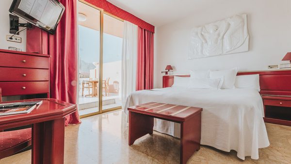 Discover the best Tenerife beach hotels, hotel room with balcony and red and white decor