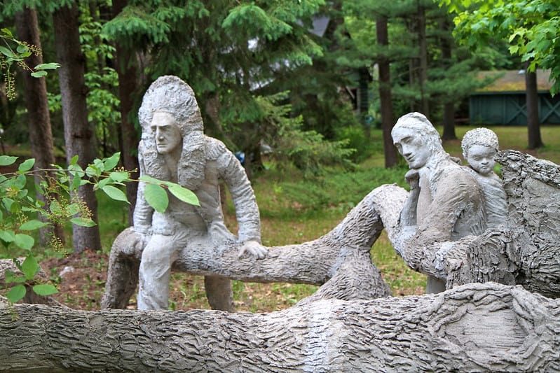 sculptures of man with wig, woman and child