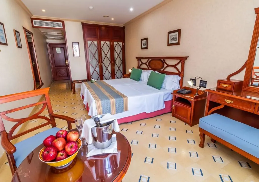 Top all-inclusive hotels in Costa Adeje, comfy hotel room with a bowl of apples and wine bucket on table