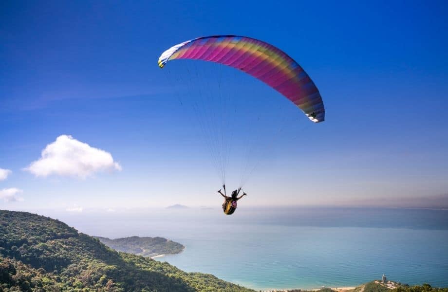 Adventurous things to do in Tenerife, person paragliding over an island