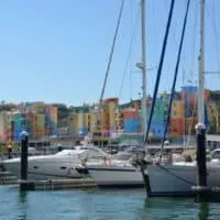 day trips from Lagos Portugal, boats docked on marina with colorful buildings in background