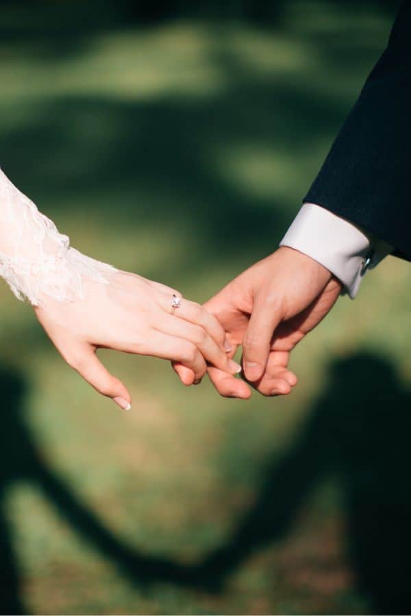 a bride and groom holding each other's hand
