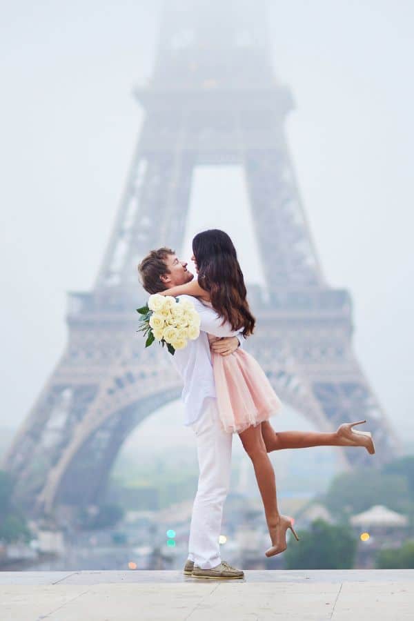 a couple posing in front of the Eiffel tower