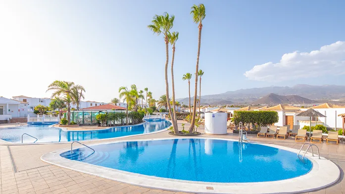 Best spa hotels in south Tenerife, resort area with two large pools and view of mountains in distance