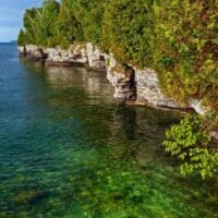 best places to hike in Door County, rocky cliffs along shoreline next to clear blue water