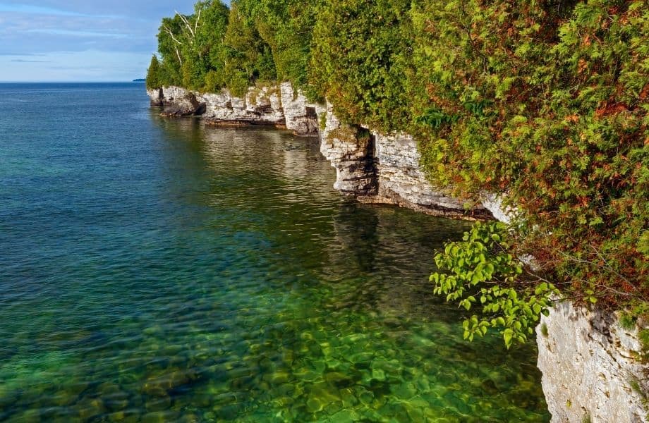 best places to hike in Door County, rocky cliffs along shoreline next to clear blue water