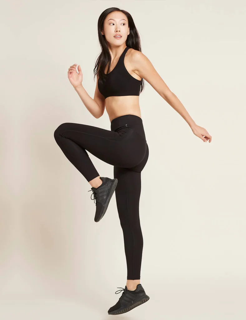 eco friendly bamboo yoga pants, woman stretching in black leggings and bra