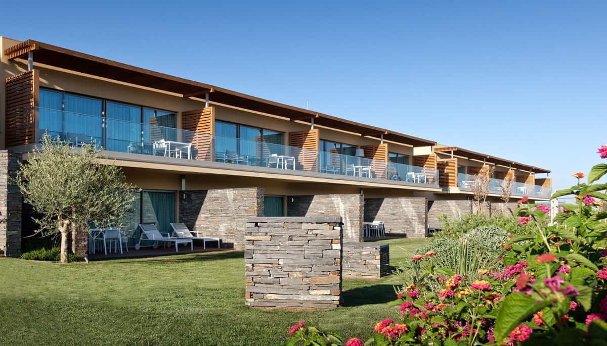 Accommodation In Albufeira, outside view of a block of hotel rooms all with balconies and seating that overlooks the garden. where to stay in algarve for couples