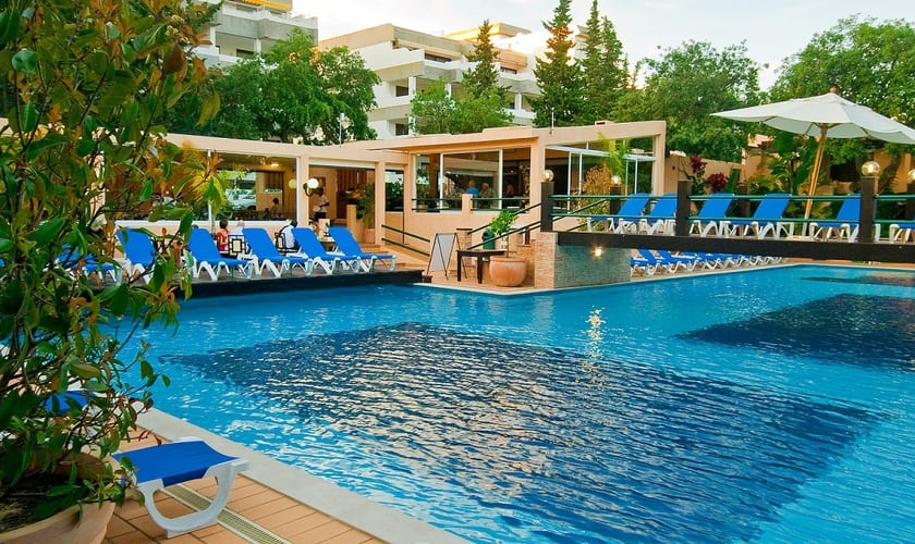 amazing hotels in Albufeira Portugal, outside pool area with blue deck chairs and a walkway over the middle of the pool